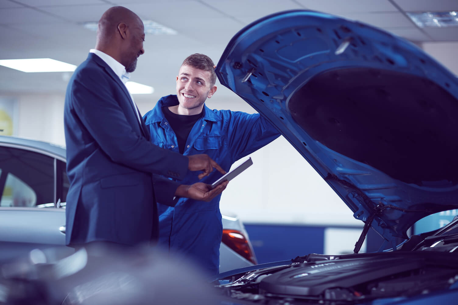 Customer looking under the hood of a car