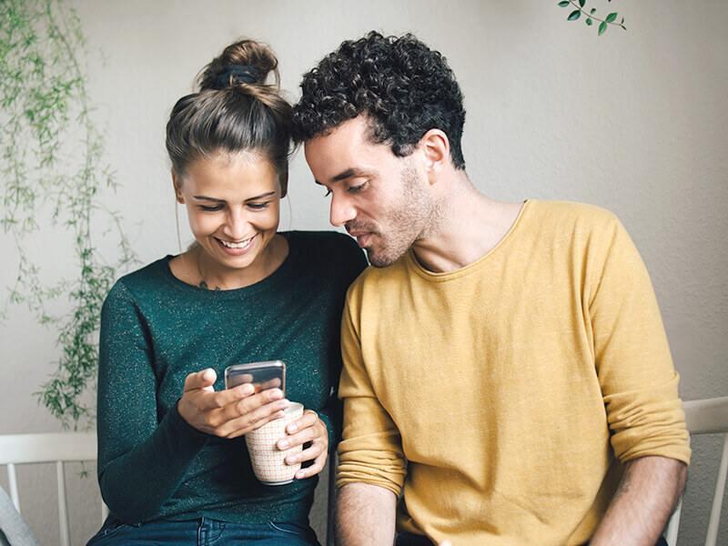 Smiling couple showing smartphone