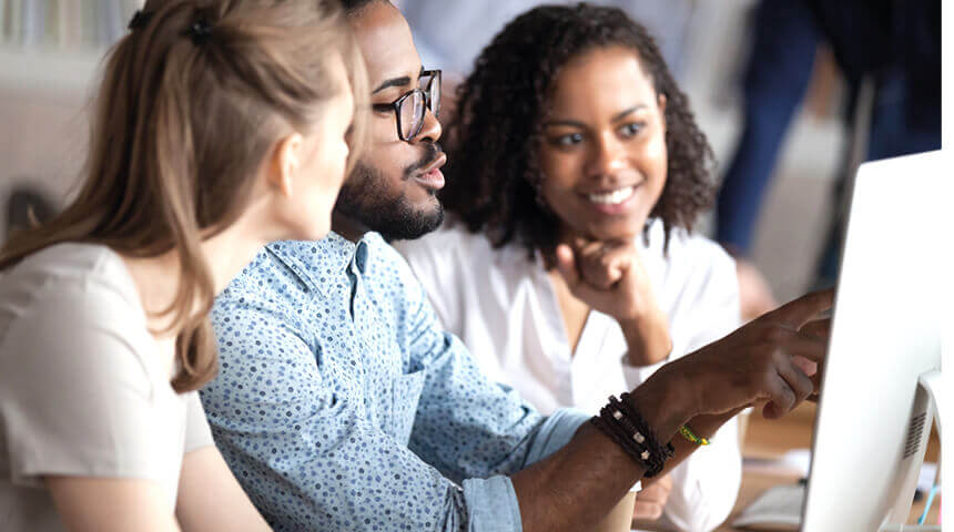 Three people working together on computer